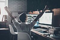 Youth at computer raising fists triumphantly